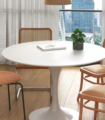 A white round modern dining table in a contemporary dining room, offering a sleek and stylish look.