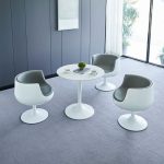 Modern round white dining table with a sleek design, perfect for contemporary dining rooms and stylish home interiors.