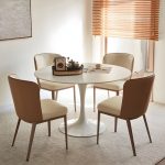 Modern round white dining table with a sleek design, perfect for contemporary dining rooms and stylish home interiors.
