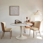 Modern round white dining table with a sleek design, perfect for contemporary dining rooms and stylish home interiors.