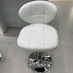 Simple black leather square bar stool with a modern design and sturdy base.