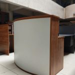 A sleek, curved front reception station with modern design, offering a stylish and functional workspace for professional environments.