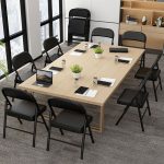 A black foldable office chair with a sleek design, offering portability and space-saving functionality, perfect for flexible office setups.