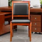 A wooden visitor’s office chair with a comfortable padded seat, sturdy wooden frame, and armrests, offering a stylish seating option for office guests.