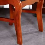 A wooden visitor’s office chair with a comfortable padded seat, sturdy wooden frame, and armrests, offering a stylish seating option for office guests.