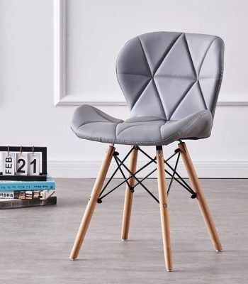 A stylish Eames dining chair with a molded plastic seat in a neutral color, sleek wooden legs, and a modern design, perfect for contemporary dining spaces.